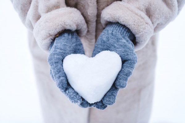 Cropped-shot-of-person-holding-heart-symbol-made-from-snow Cropped shot of person holding heart symbol made from snow